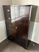 Front view of vintage dark brown wooden dresser showing five drawers with metal handles on the left and a tall cabinet door on the right.