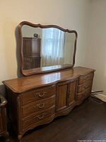 Front angle view of the vanity with mirror showing detail of drawers and wood grain.
