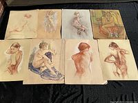 Overview of eight sketches laid flat on black cloth