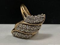 Angled front view showing three curved rows of diamonds on yellow gold band