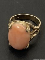 Front view of ring showing oval coral cabochon and prong setting