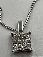 Close-up of square pendant showing 16 diamonds in 4x4 grid