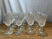 Group of 16 goblets arranged on a wooden surface against a draped backdrop