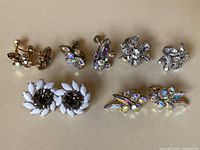 Overall view of all five pairs of signed vintage Sherman earrings, showing variety of rhinestone designs and settings of clip-on and screw-back types.