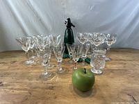 Full view of all crystal glasses, jars, and seltzer bottle on wooden table