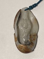 Front view of hand-carved white and brown jadeite pendant