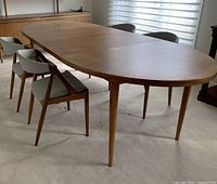 Full view of oval table extended with two leaves, showing overall design and finish
