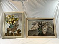 Two framed paintings side by side against backdrop