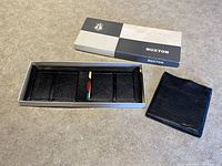 New black Buxton wallet with its original box and inner packaging tray on display.