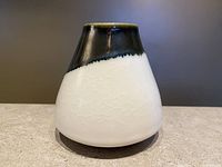 Front view of the pear-shaped ceramic vase showing the crackled white lower glaze and dark upper glaze with drips.