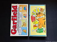 Closed Garfield board game box with Garfield logo and comic strip panels