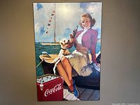 Full view of the Coca-Cola advertising poster on plaque showing woman and dog on boat by dock with Coca-Cola cooler