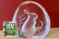 Clear full lead crystal paperweight with detailed bunny figure etched inside surrounded by grass foliage. Målerås Sweden full lead sticker visible.