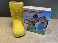 Yellow ceramic boot planter with white polka dots, visible small chip near top.