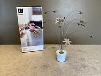 Photo of Umbra Petal Photo Display with original retail box, showing product packaging and branding.