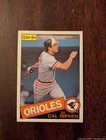 Front of the 1985 O-Pee-Chee Cal Ripken baseball card in Orioles uniform swinging a bat.