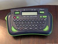 Front view of Brother PT-80 label maker showing keyboard, screen, and print button.