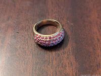 Top view of dome-shaped band encrusted with three rows of round pink sapphires