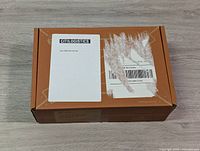 Box front side showing shipping label and Citilogistics branding with some tape residue and scratch marks but box is intact.