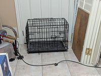 Folded view of the wire pet crate showing its compactness and one locked door.