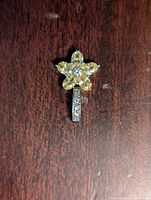 Front view of sterling silver flower pendant with yellow stones and clear stone center, showing vertical bail with clear stones.