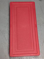 Top view of red plastic underbed storage container lid, ribbed textured surface