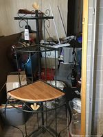 Bakers rack showing full structure with metal frame and wooden shelf corner, with decorative metal accents