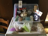 Photo showing entire bin with various bags of beads and shells spread in front of it on a table.