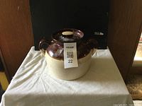 Photo of the antique Roseville USA bean pot showing the front with lid on and two loop handles.