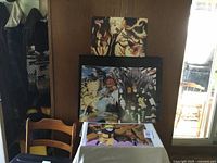 Four Naruto Comicon prints displayed, three leaning against wall, one flat on table