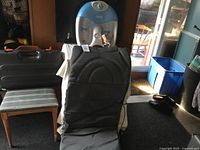 Photo showing black vibrating seat massager upright with foot massager behind on chair