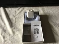 True wireless earbuds in open charging case with box and MaxSold tag.