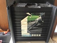 Photo shows the folded pet ramp in black with a handle and product label featuring a dog using the ramp outdoors.