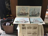 Four prints displayed, three showing tall ships on water and one informational print about tall ships.