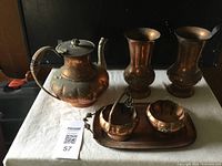 Old Venetian copper items including teapot, two vases, sugar bowl, creamer, and tray on a white cloth
