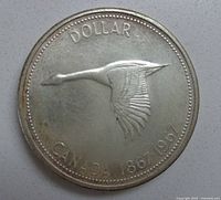 Obverse side of the 1967 Canadian silver dollar coin showing a flying goose and dates 1867-1967.