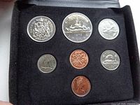 Six Canadian coins arranged in black velvet case: 10-cent, 1-dollar, 5-cent, 1-cent, penny, and 25-cent coins.