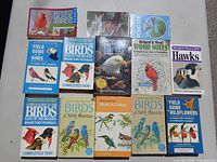 Photo showing 12 bird and nature guide books including Beginners Guide to Birds, National Geographic Birds of North America, and Peterson Field Guides.