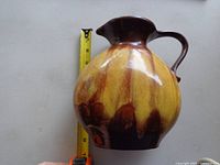 Side view of pottery vase with measuring tape showing approx 8.5 inches height and 7 inches width