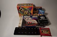 Photo showing the collection of five board games including Best of TriBond, Input, The Mole, Ramen Fury with game board tray visible.