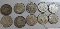Ten Canadian 50 cent coins showing reverse coat of arms and overall condition on a flat surface.