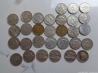 Top view of Canadian nickel coins arranged in rows, varying dates from 1937 through 1967, showing front with beaver design and some reverse date sides.