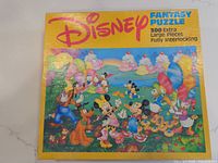 Photo of Disney Fantasy Puzzle box showing vibrant fantasy illustration with Disney characters and listing 300 extra large fully interlocking pieces.