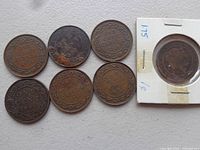 Seven large Canadian pennies from early 1900s along with one 1859 penny in white coin holder. Coins show dated years and varying wear.