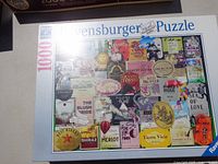Front of Ravensburger puzzle box showing 1000 pieces and collage of wine labels artwork
