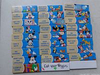 Photo showing 27 vintage Disney magnetic chore reminder magnets lined in rows on a white surface, characters include Mickey Mouse, Pluto and Donald Duck, each magnet about 3 1/2 inches by 1/2 inch with chore reminders printed.