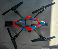 Top-down photo of the red and blue drone showing its sleek aerodynamic body and four propellers.