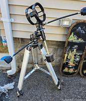 Tripod fully extended showing pan handle, mounting ring, and counterweight for stability.