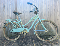 Full side view of the vintage Huffy 24 women's cruiser bike in mint blue with rear rack, cushioned seat, and chain guard.