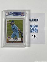 Top view of the graded and encased Bo Bichette baseball card with MaxSold support paper showing.